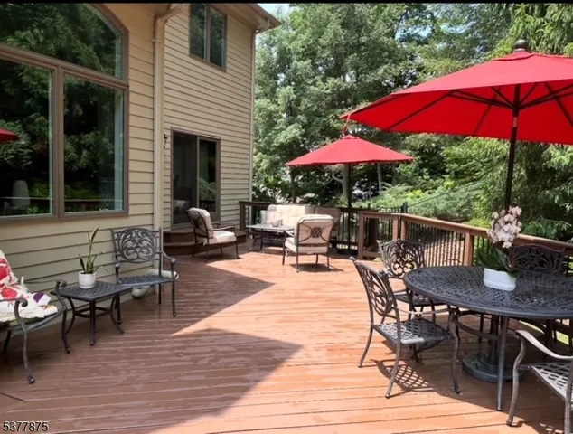 a patio with tables and chairs under an umbrella