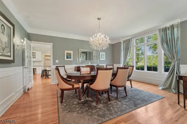 a dining room with furniture a chandelier and wooden floor