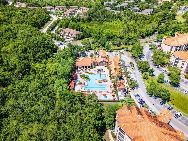 an aerial view of residential house with outdoor space and trees all around