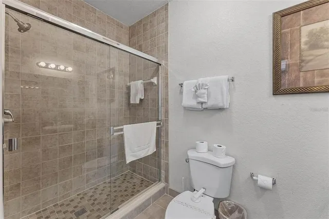 a bathroom with a toilet and a shower