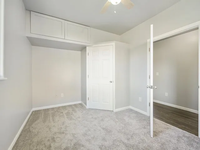 an empty room with a chandelier fan