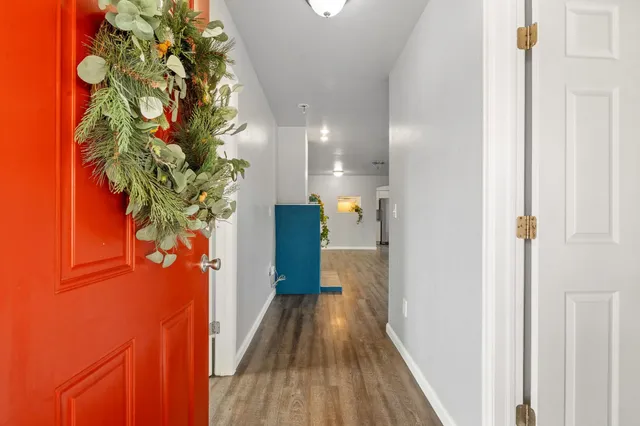 a view of a hallway with wooden floor and plant