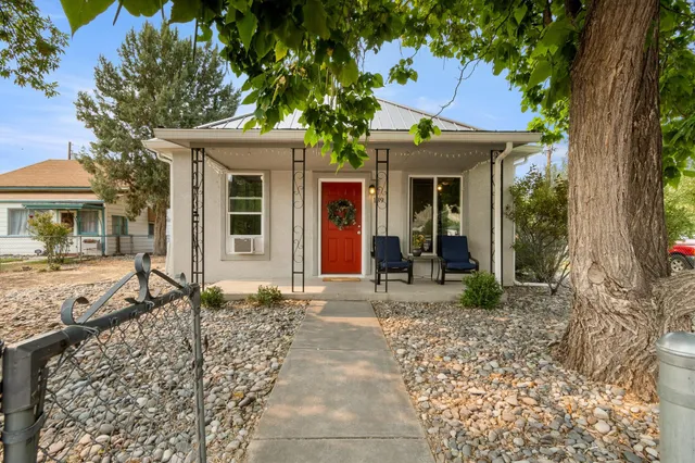 a view of a house with backyard and a tree