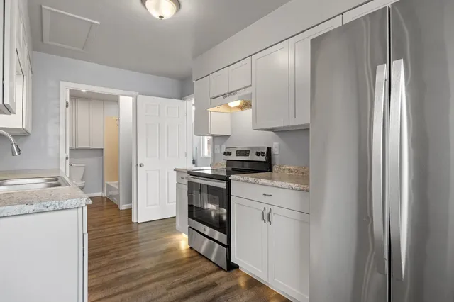 a kitchen with a sink cabinets stainless steel appliances and a window