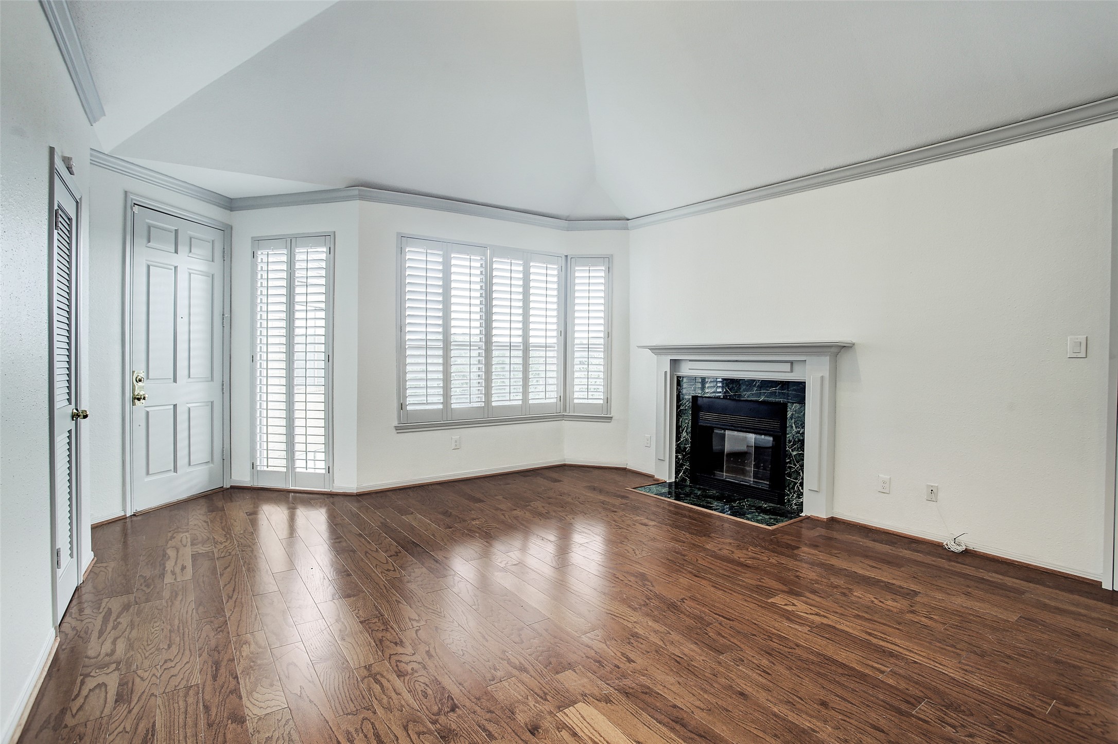 5220 Weslayan Street, Unit 310 Houston, TX 77005 - Photo 3 of 18 an empty room with wooden floor fireplace and windows