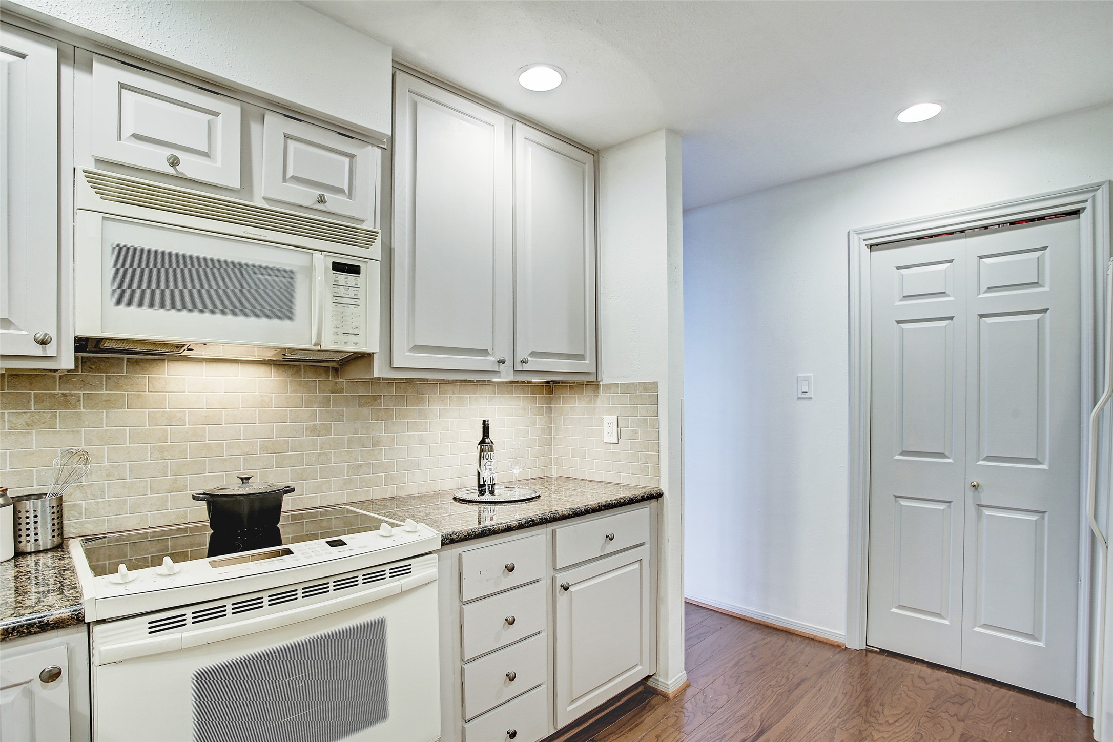 5220 Weslayan Street, Unit 310 Houston, TX 77005 - Photo 7 of 18 a kitchen with stainless steel appliances white cabinets and a stove top oven