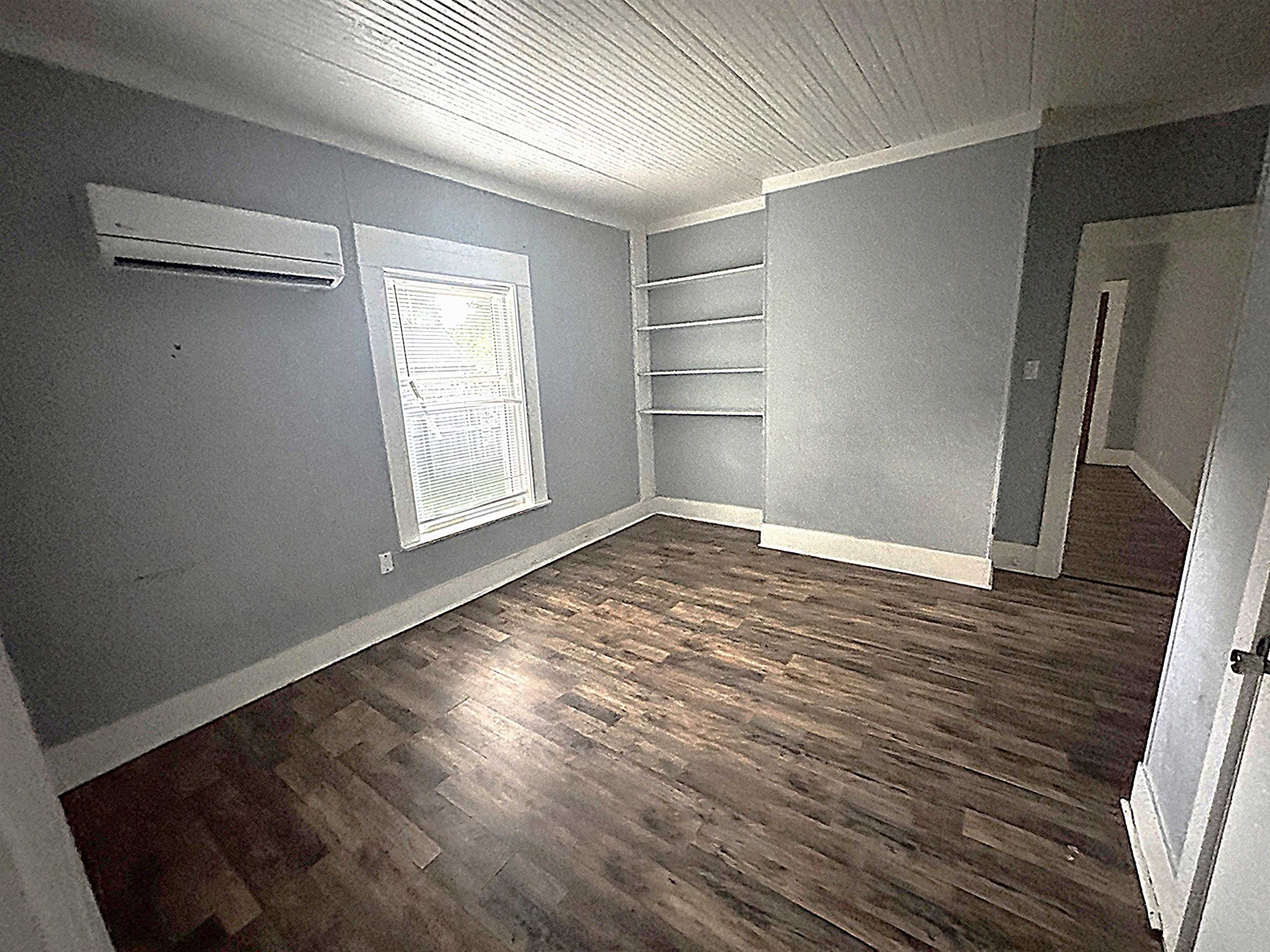 767 Semmes Street Memphis, TN 38111 - Photo 6 of 23 an empty room with wooden floor cabinet and windows