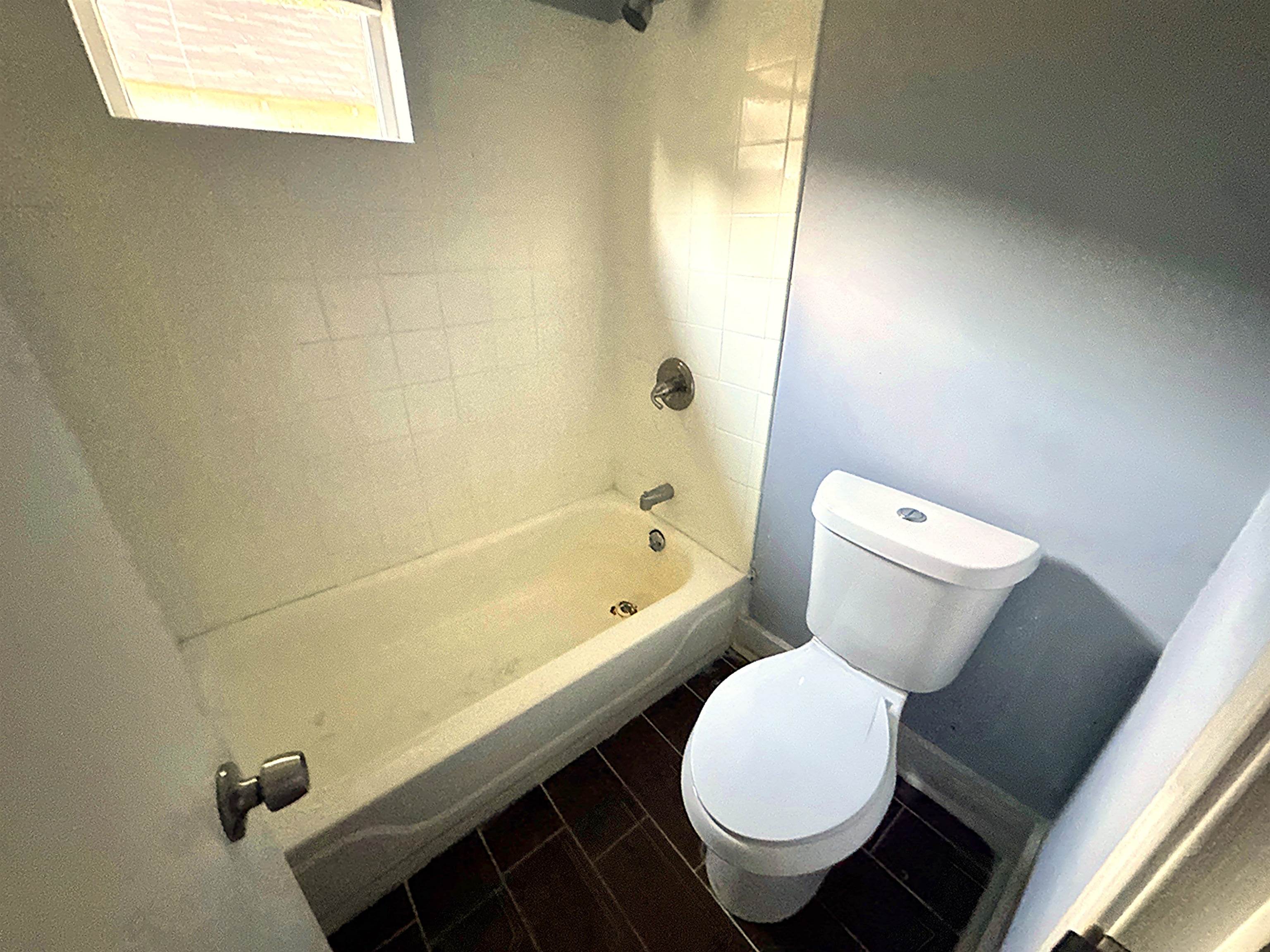 767 Semmes Street Memphis, TN 38111 - Photo 8 of 23 a bathroom with a toilet and a bathtub
