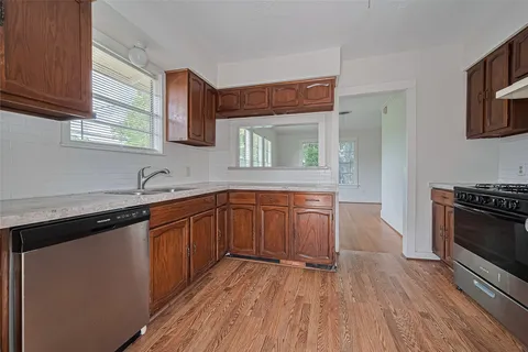 a kitchen with stainless steel appliances granite countertop a sink stove and cabinets
