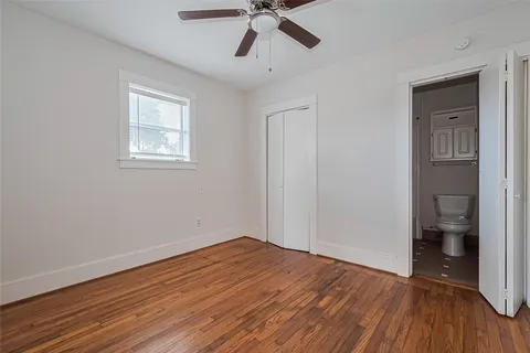 a view of empty room with wooden floor and ceiling fan
