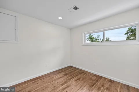 an empty room with wooden floor and window