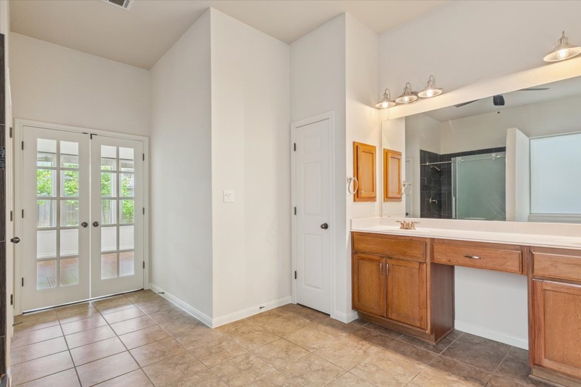 102 Country View Way Cedar Park, TX 78613 - Photo 18 of 38 Bathroom with vanity, a shower, french doors, and tile patterned flooring