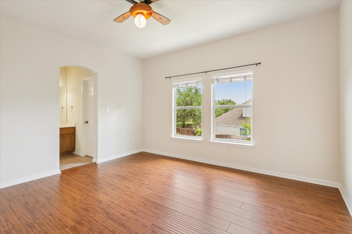 102 Country View Way Cedar Park, TX 78613 - Photo 21 of 38 Empty room with arched walkways, a ceiling fan, and light wood-style flooring
