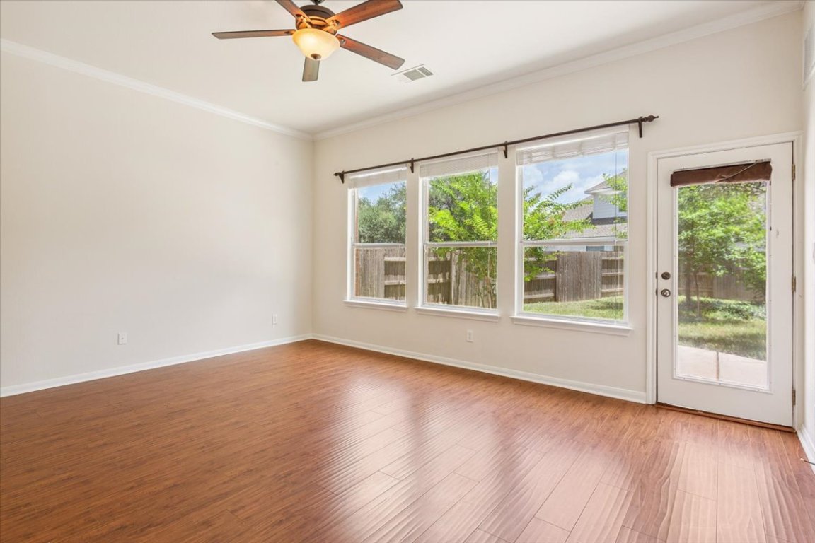 102 Country View Way Cedar Park, TX 78613 - Photo 24 of 38 Empty room featuring plenty of natural light, a ceiling fan, wood finished floors, and crown molding