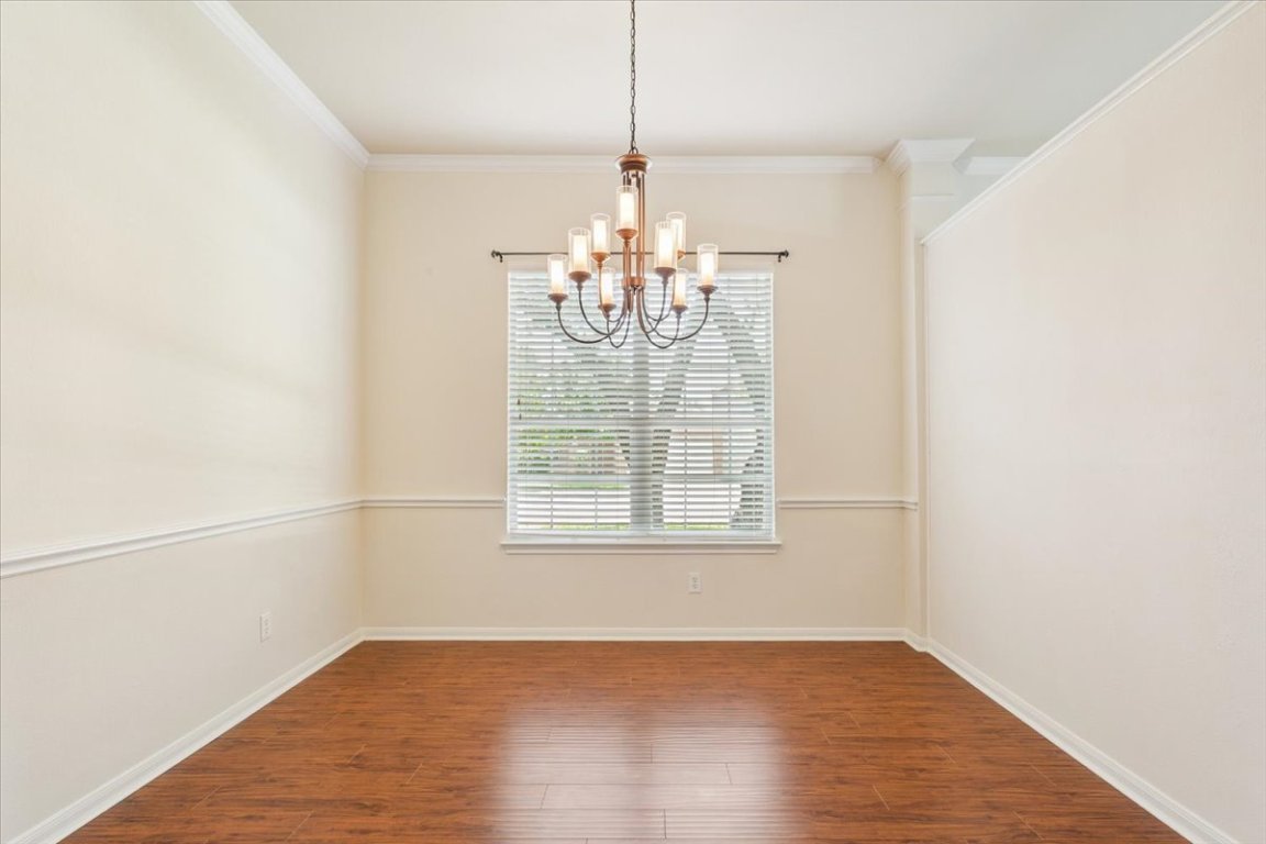 102 Country View Way Cedar Park, TX 78613 - Photo 7 of 38 Unfurnished room with a chandelier, wood finished floors, and ornamental molding