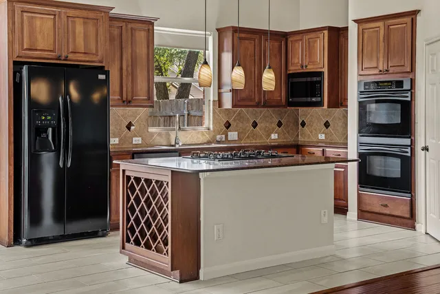 a kitchen with stainless steel appliances a stove sink microwave and refrigerator