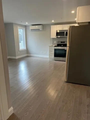 a kitchen with granite countertop a refrigerator and a stove top oven