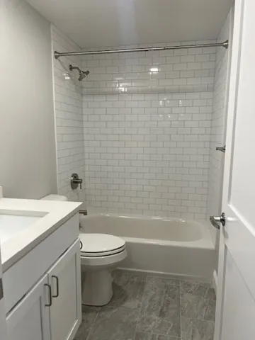 a bathroom with a shower a toilet and sink