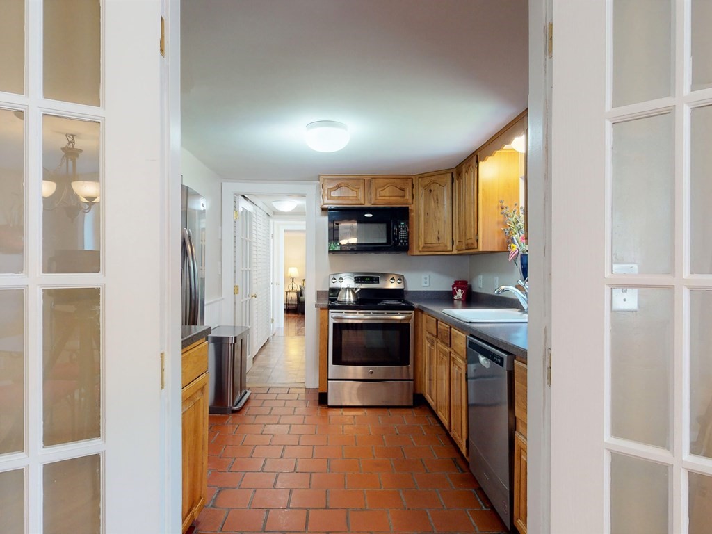 54 Carlin Road Waltham, MA 02451 - Photo 9 of 41 a kitchen with stainless steel appliances granite countertop a refrigerator and a stove top oven