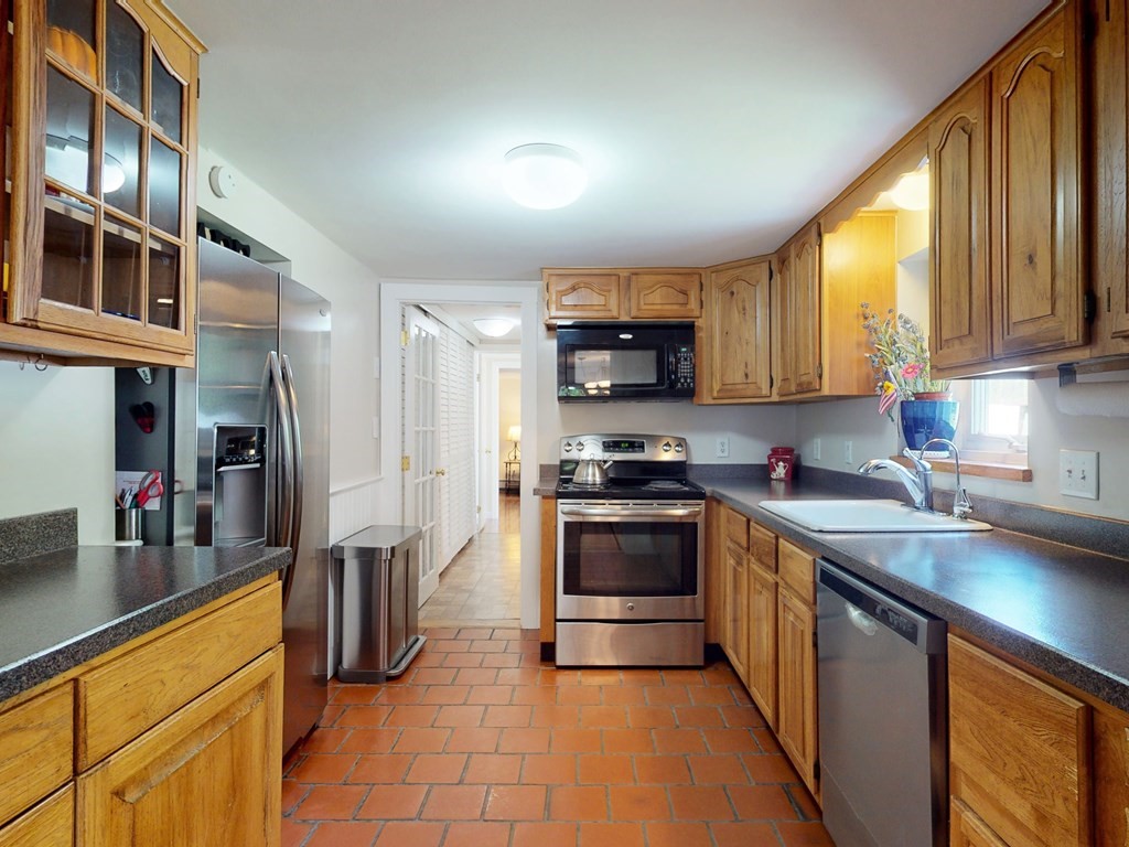 54 Carlin Road Waltham, MA 02451 - Photo 10 of 41 a kitchen with stainless steel appliances a stove sink microwave and cabinets