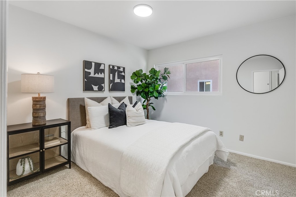 214 Angelo Walk Long Beach, CA 90803 - Photo 24 of 36 a bedroom with a bed and a potted plant