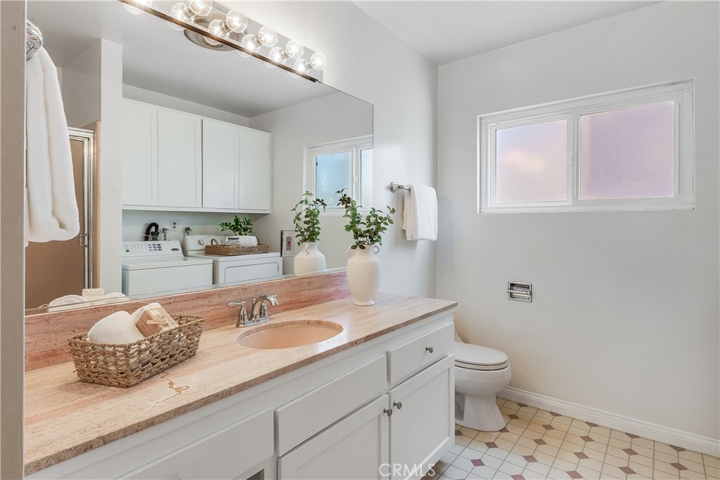 214 Angelo Walk Long Beach, CA 90803 - Photo 25 of 36 a bathroom with a granite countertop sink a toilet and a mirror