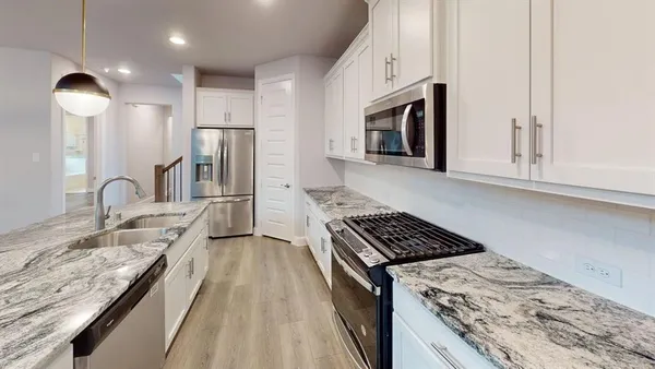 a kitchen with granite countertop a stove and a sink