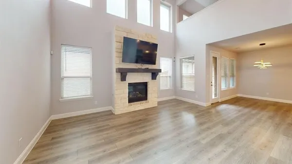 a view of a livingroom with a fireplace wooden floor and windows