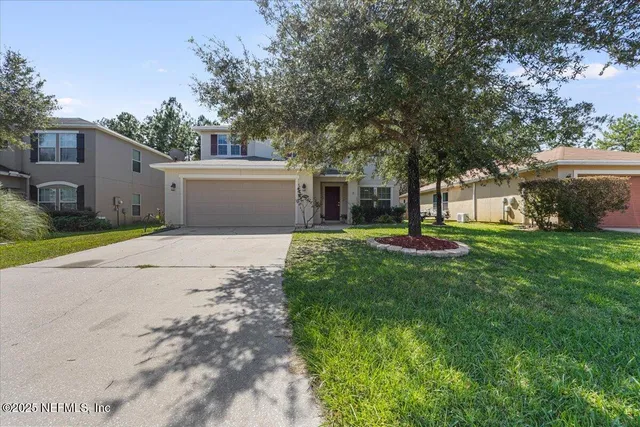 a view of a house with yard and tree s
