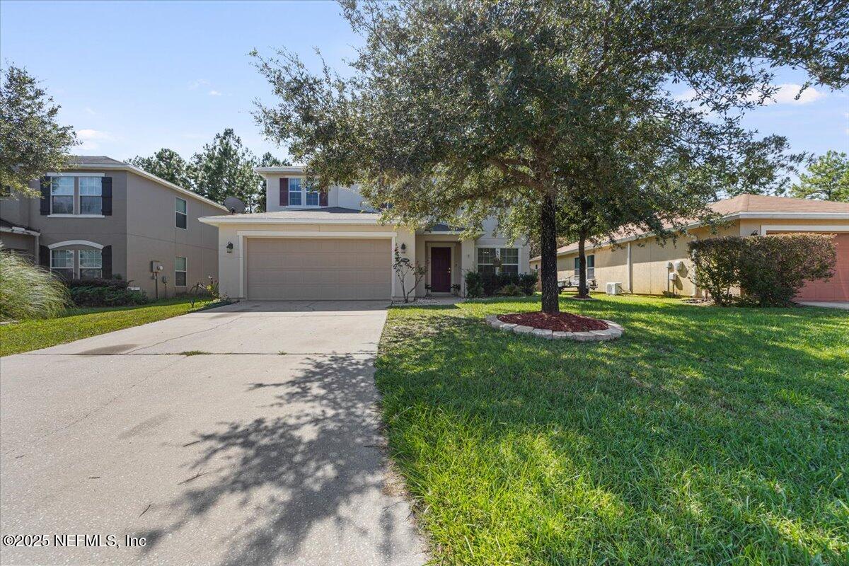 a view of a house with yard and tree s
