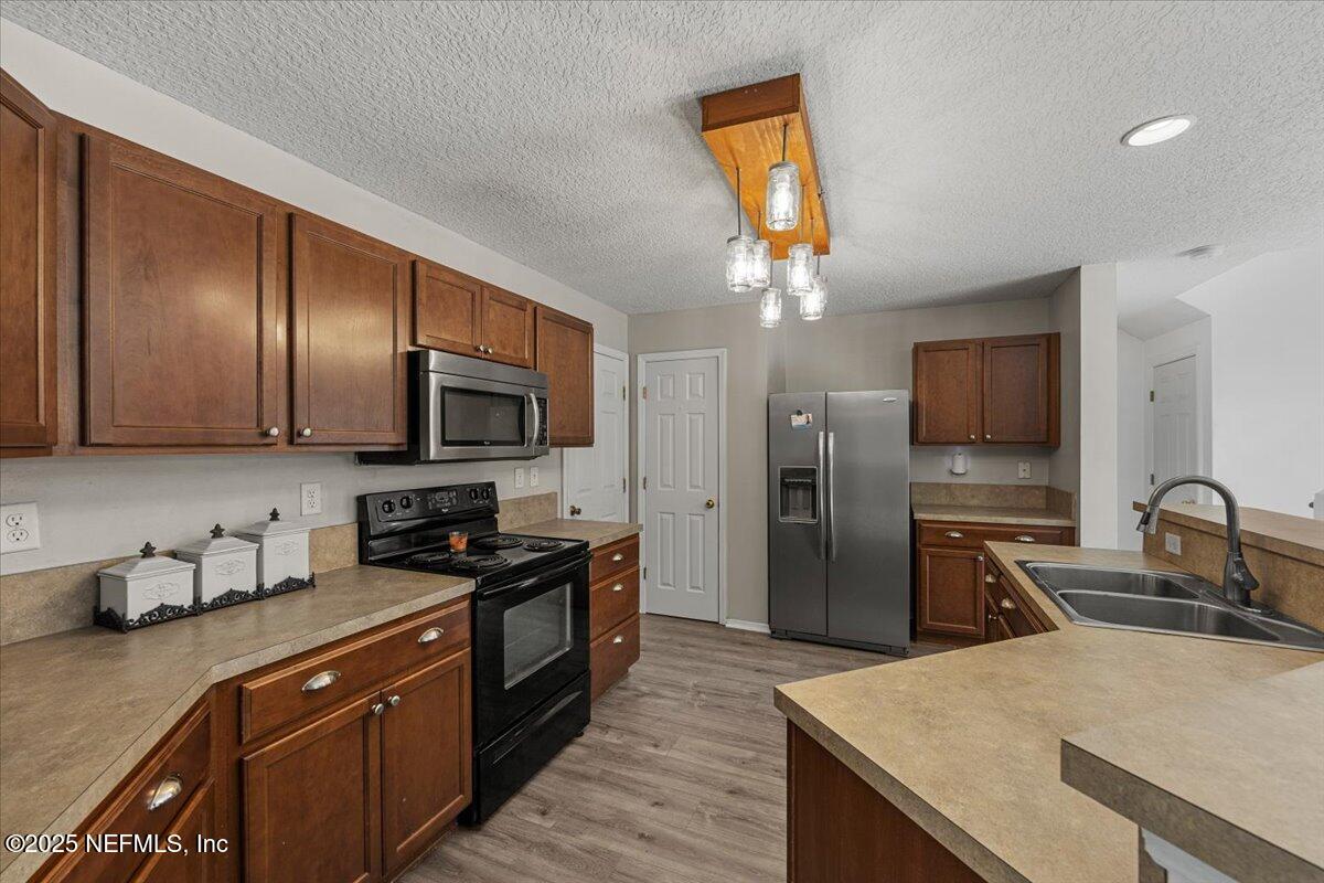 77347 Cobblestone Drive Yulee, FL 32097 - Photo 11 of 35 a kitchen with stainless steel appliances granite countertop a sink stove and refrigerator