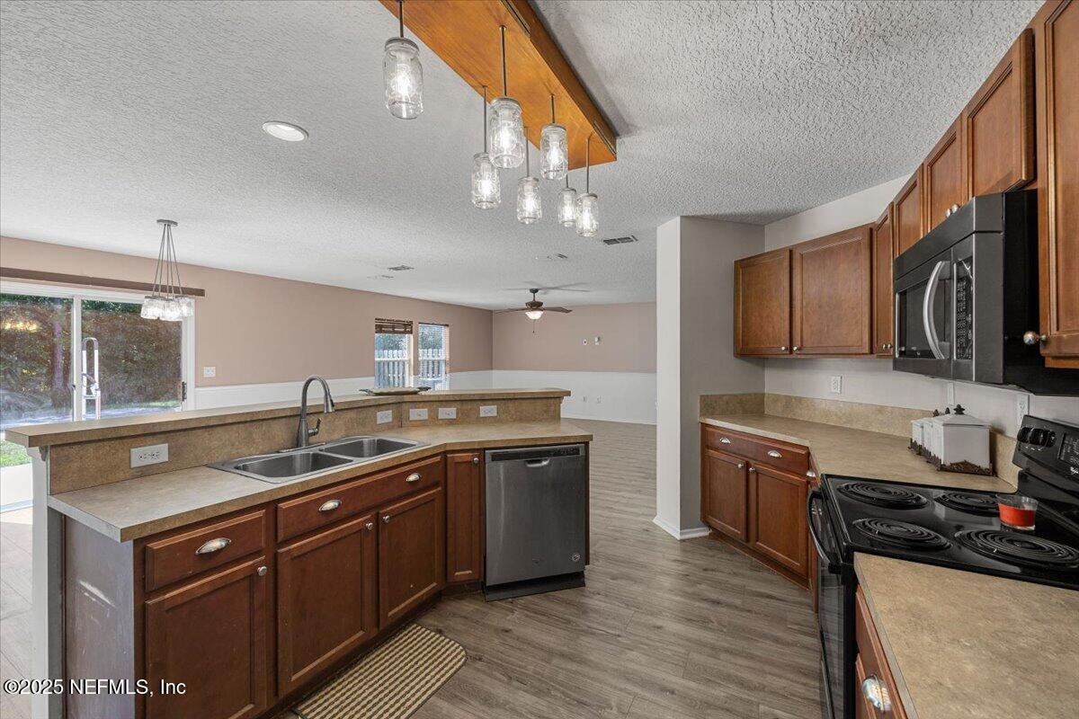 77347 Cobblestone Drive Yulee, FL 32097 - Photo 12 of 35 a kitchen with stainless steel appliances granite countertop a sink stove and refrigerator