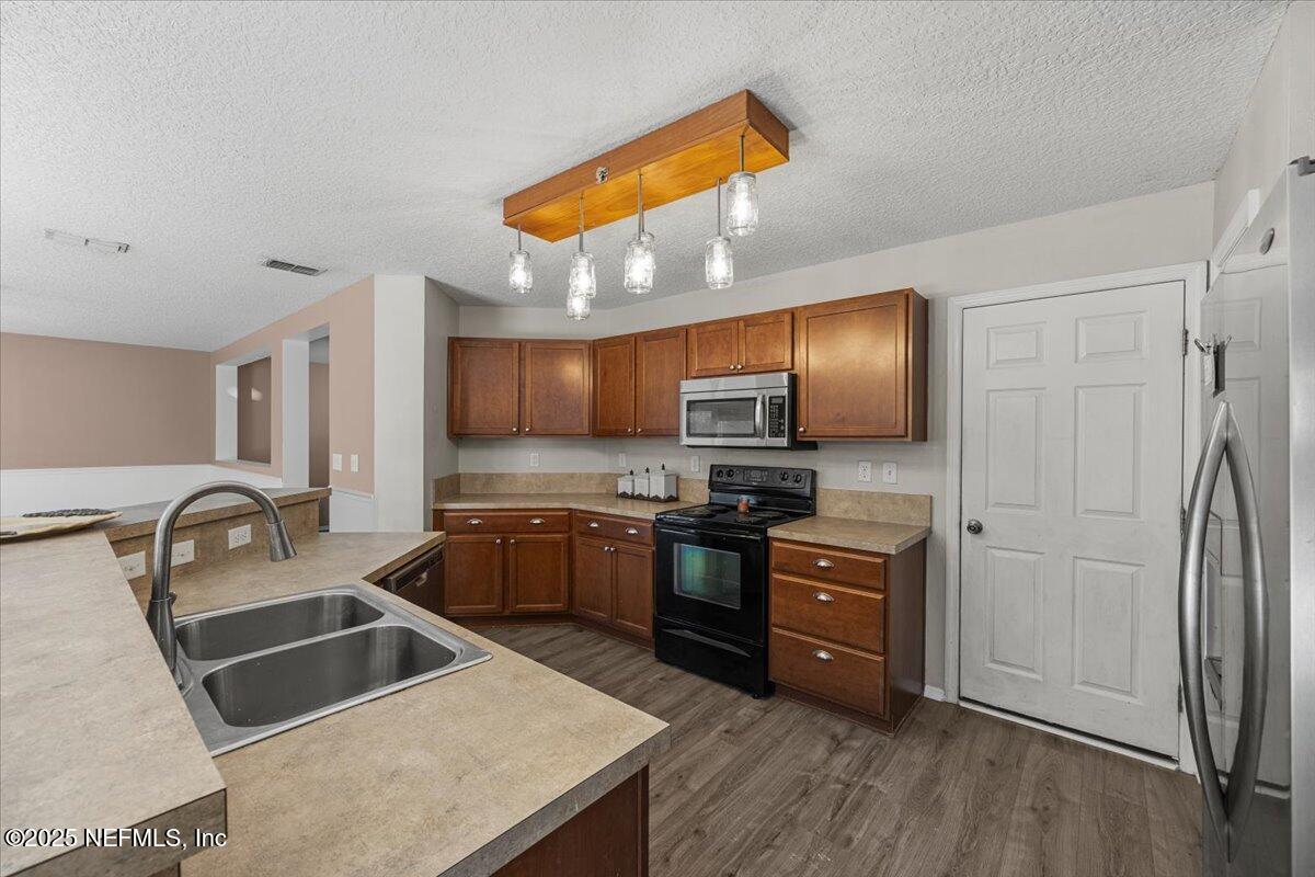 77347 Cobblestone Drive Yulee, FL 32097 - Photo 13 of 35 a kitchen with granite countertop a sink cabinets and stainless steel appliances