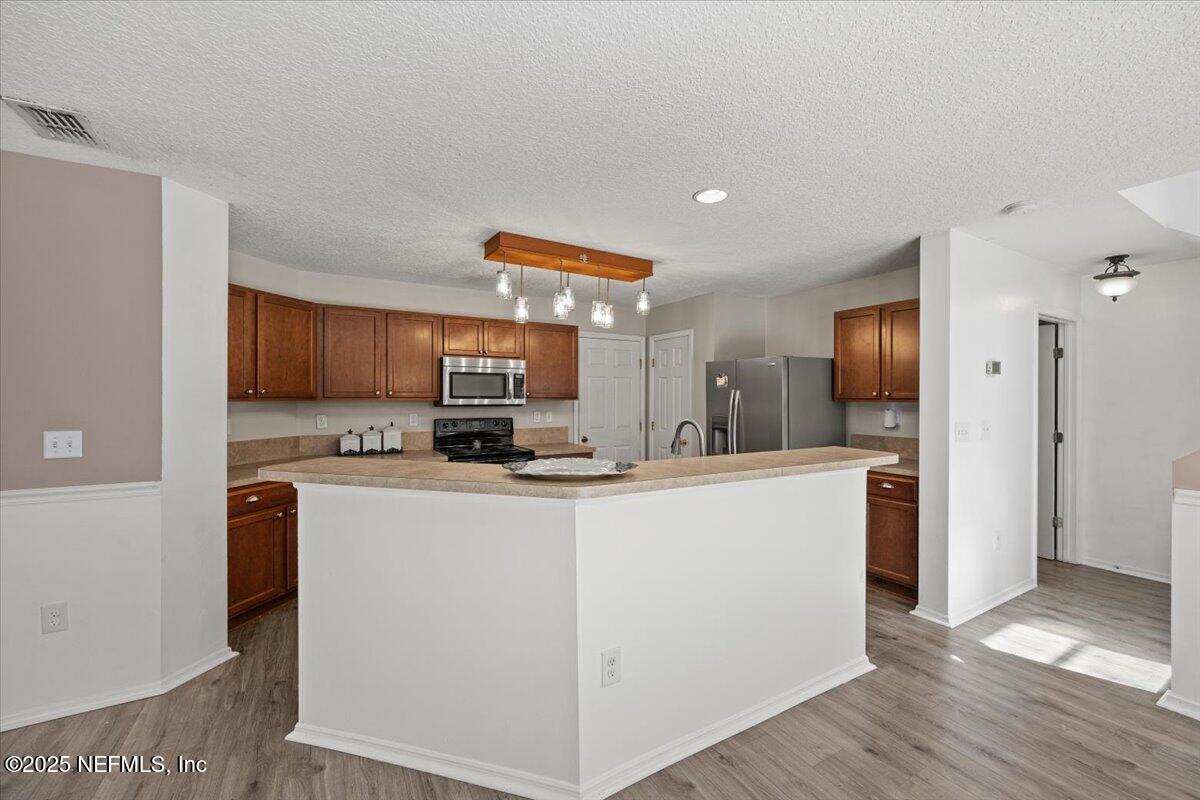 77347 Cobblestone Drive Yulee, FL 32097 - Photo 14 of 35 a kitchen with stainless steel appliances a refrigerator and a stove top oven