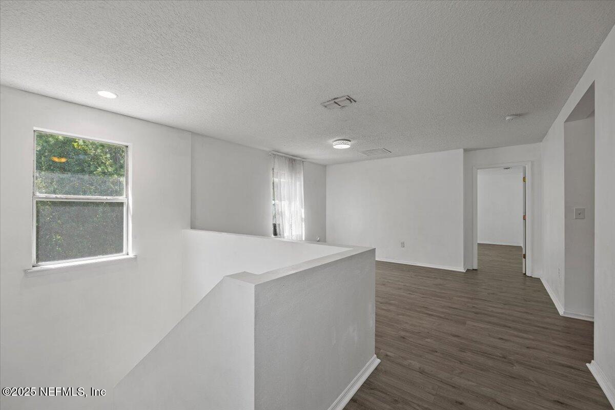77347 Cobblestone Drive Yulee, FL 32097 - Photo 19 of 35 a view of an empty room with wooden floor and a window