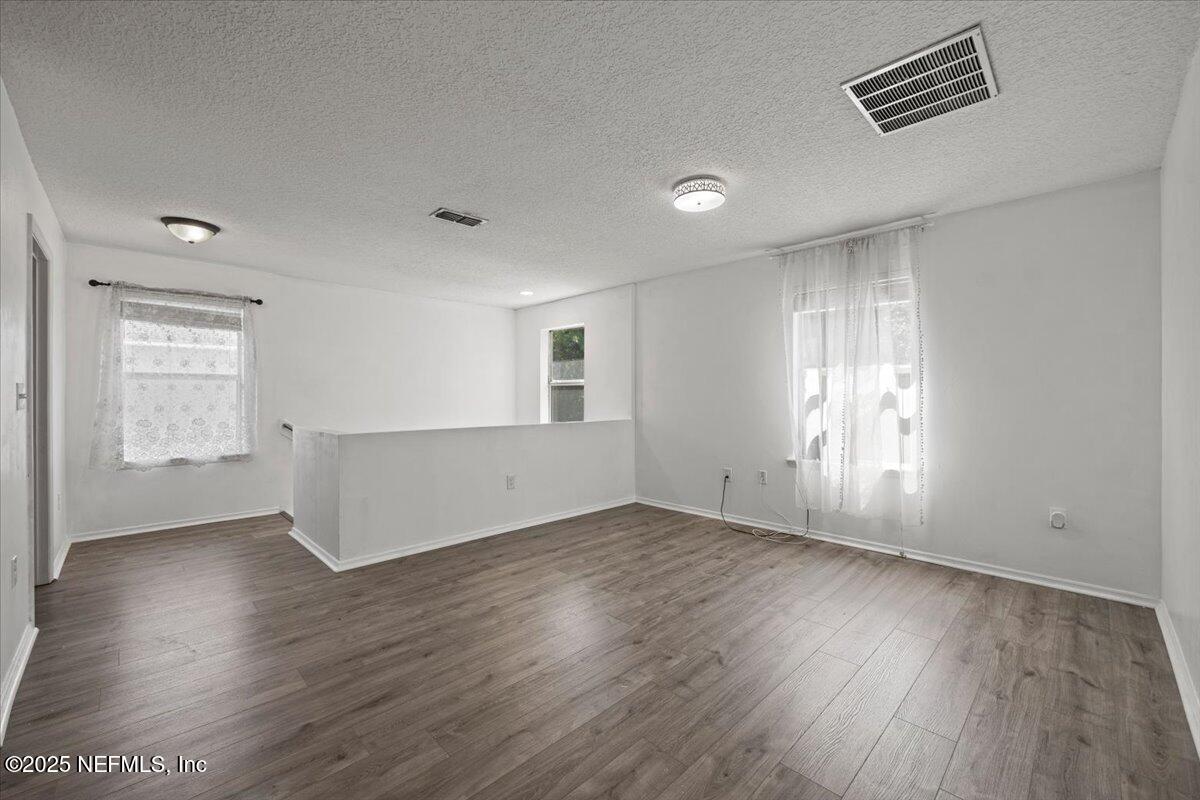 77347 Cobblestone Drive Yulee, FL 32097 - Photo 21 of 35 an empty room with wooden floor and windows