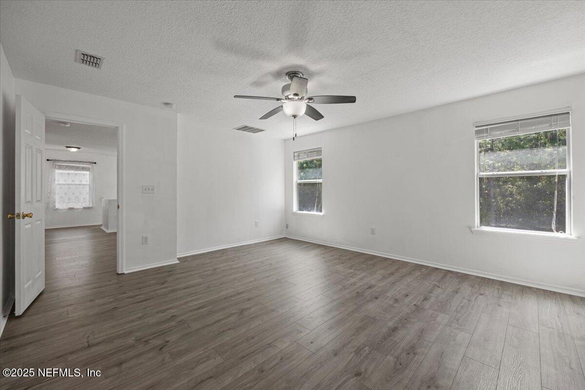 77347 Cobblestone Drive Yulee, FL 32097 - Photo 23 of 35 a view of an empty room with a window and wooden floor