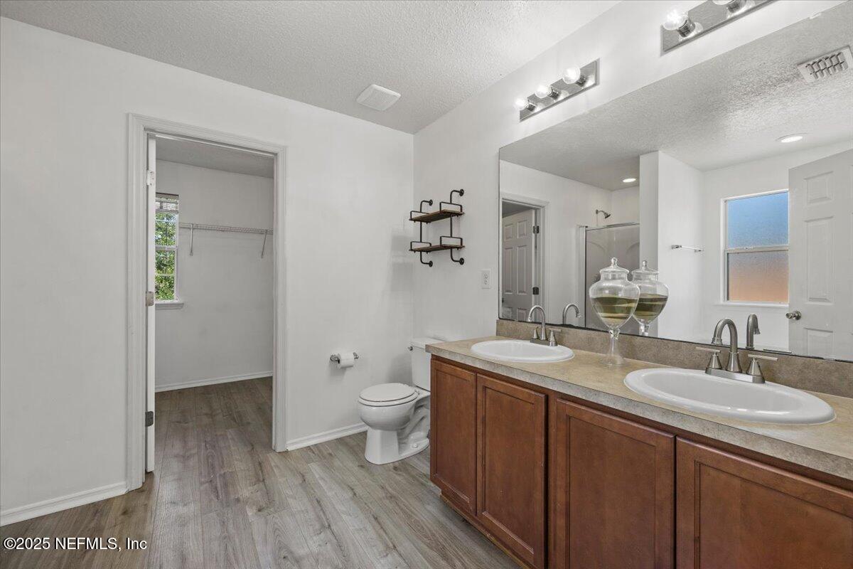 77347 Cobblestone Drive Yulee, FL 32097 - Photo 25 of 35 a spacious bathroom with a granite countertop sink toilet and shower