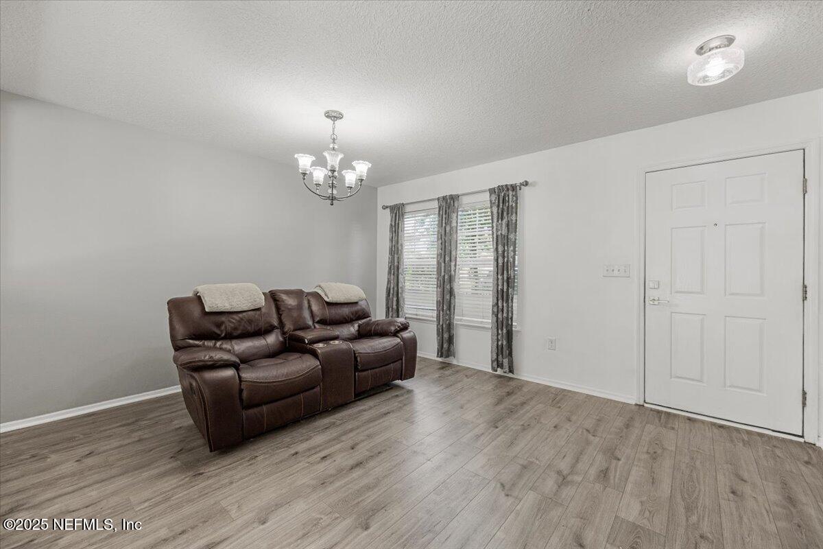 77347 Cobblestone Drive Yulee, FL 32097 - Photo 5 of 35 a living room with furniture and a chandelier