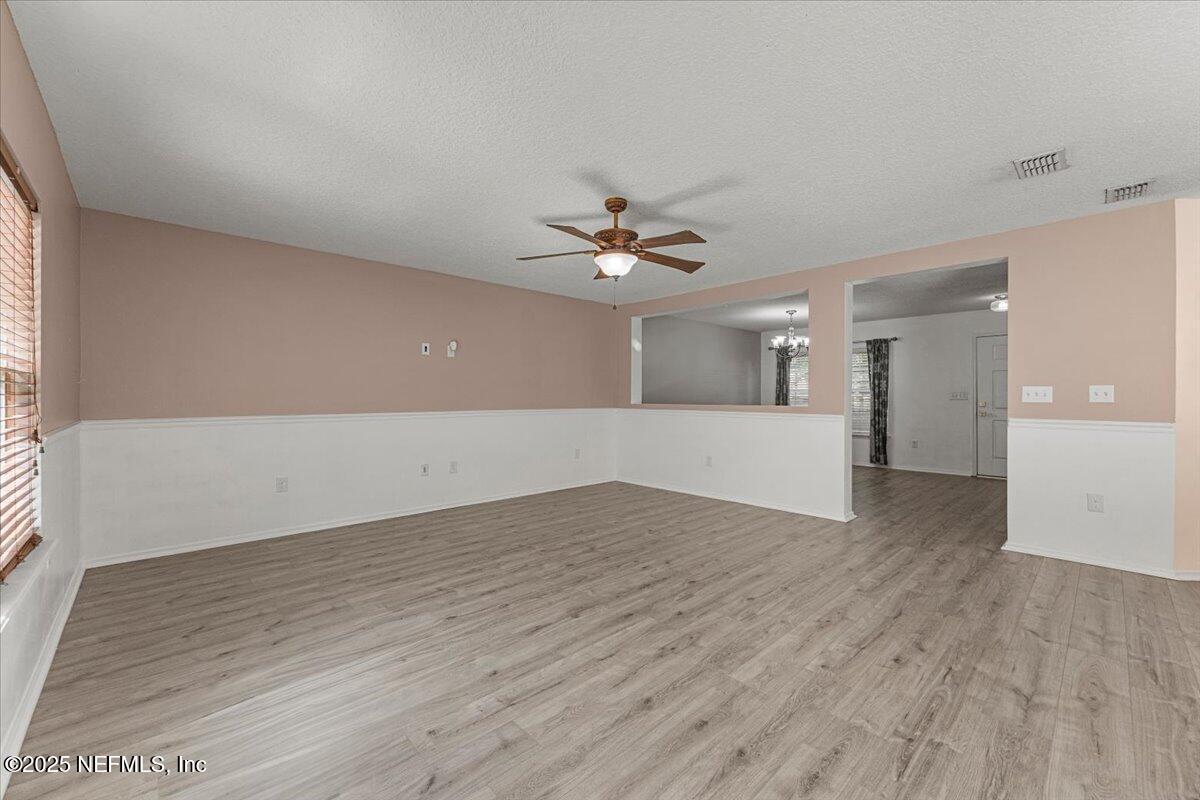 77347 Cobblestone Drive Yulee, FL 32097 - Photo 9 of 35 wooden floor in an empty room with a window