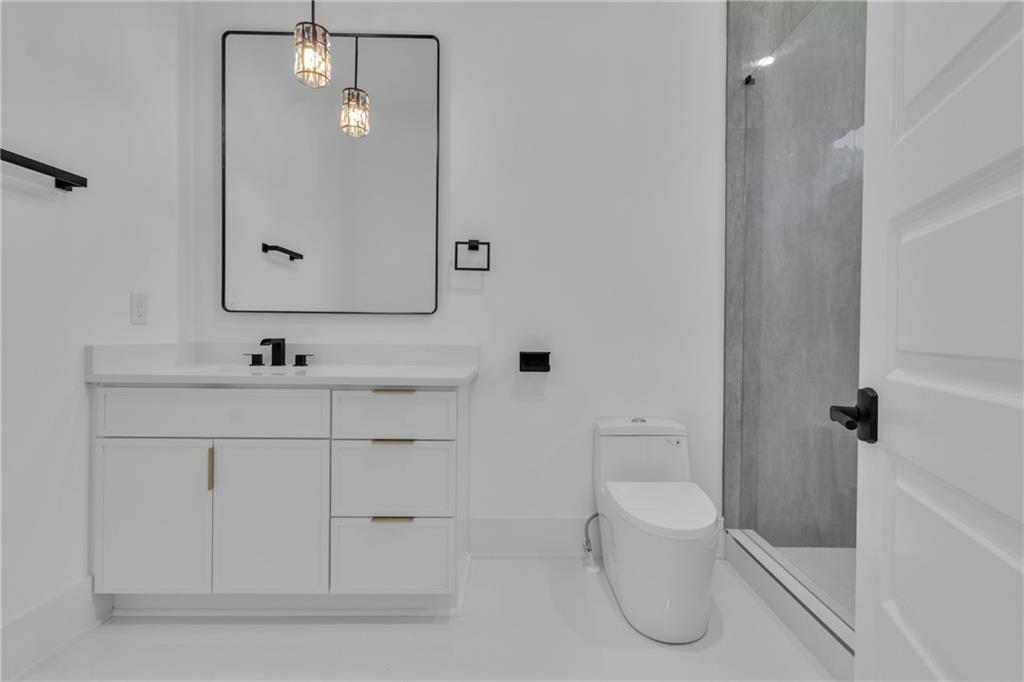 1939 Sunny Hill Road Lawrenceville, GA 30043 - Photo 11 of 47 a bathroom with a toilet sink and mirror