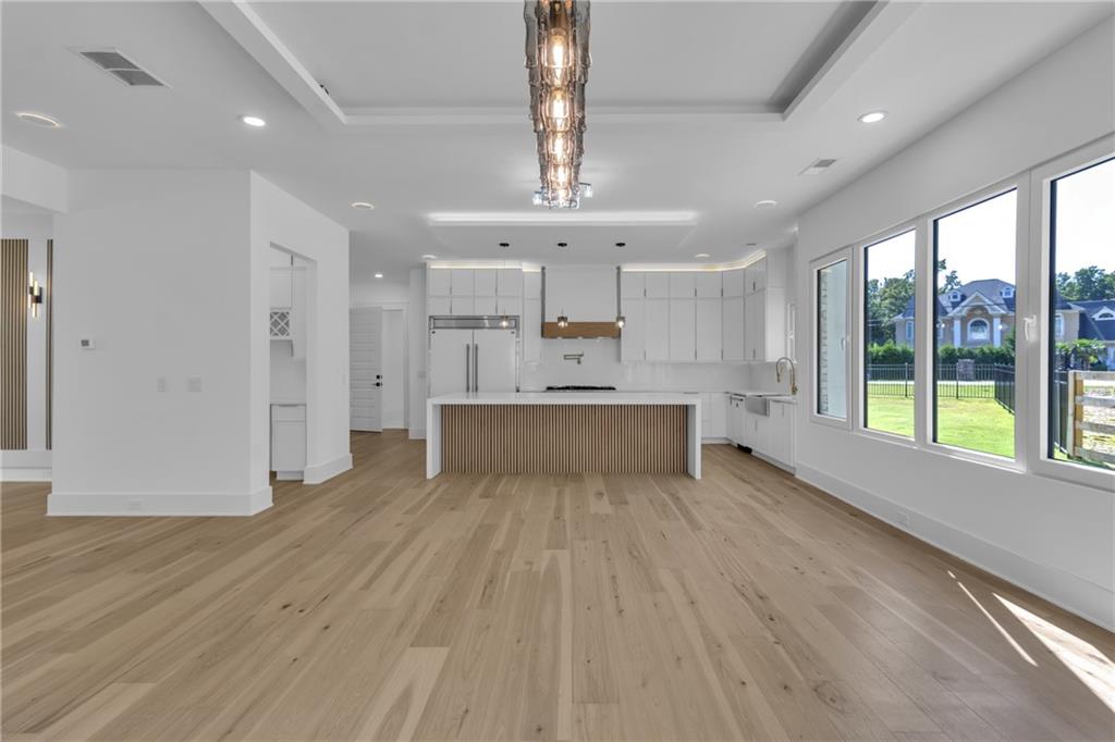 1939 Sunny Hill Road Lawrenceville, GA 30043 - Photo 14 of 47 a large white kitchen with wooden floors and view living room