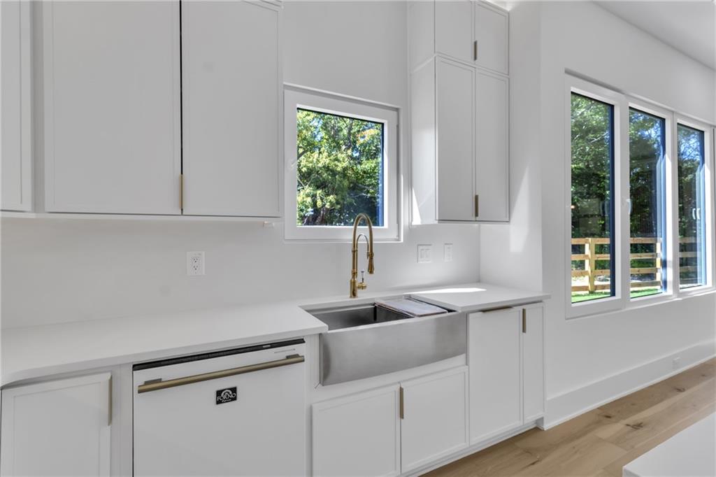 1939 Sunny Hill Road Lawrenceville, GA 30043 - Photo 16 of 47 a kitchen with stainless steel appliances a sink a window and a counter space