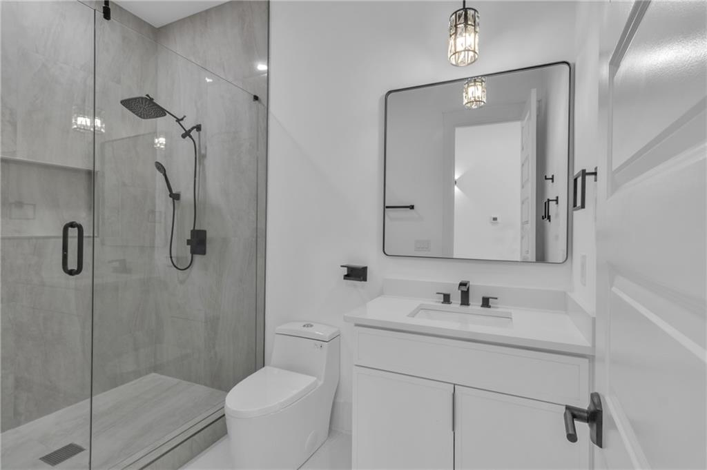 1939 Sunny Hill Road Lawrenceville, GA 30043 - Photo 26 of 47 a bathroom with a shower sink vanity mirror and toilet