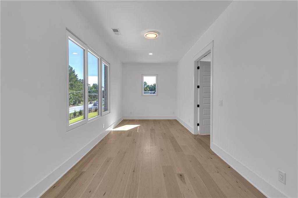 1939 Sunny Hill Road Lawrenceville, GA 30043 - Photo 29 of 47 a view of an empty room with wooden floor and a window