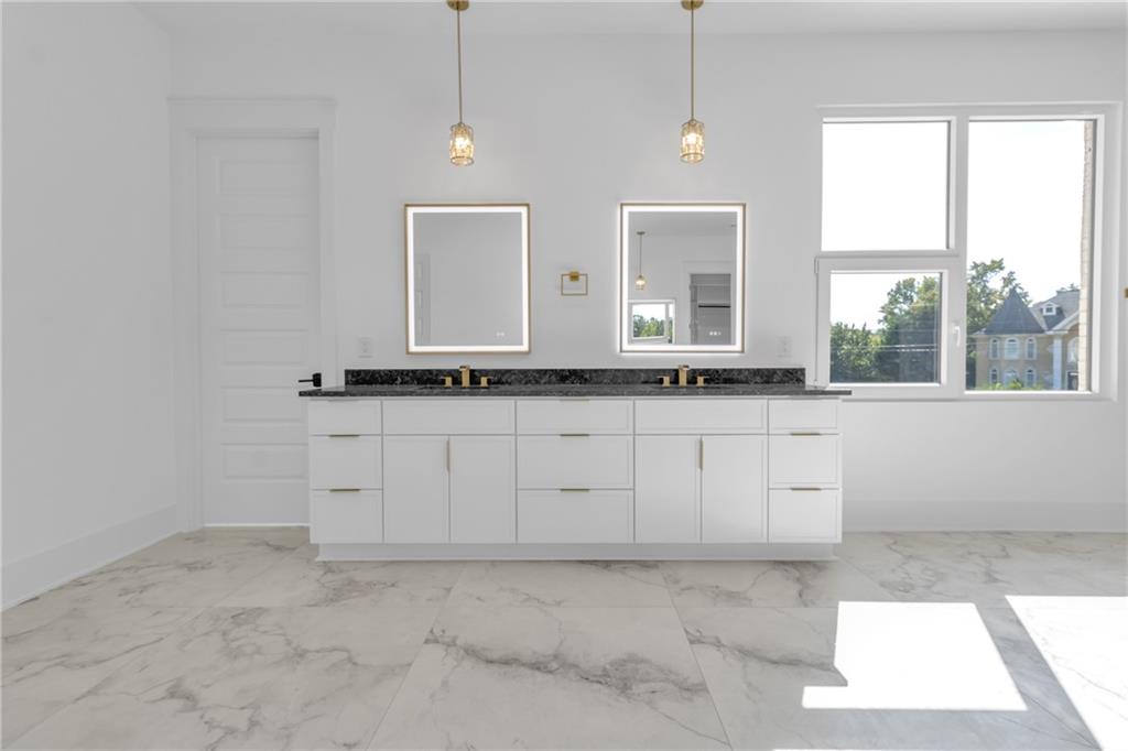 1939 Sunny Hill Road Lawrenceville, GA 30043 - Photo 32 of 47 a bathroom with a granite countertop sink and a mirror