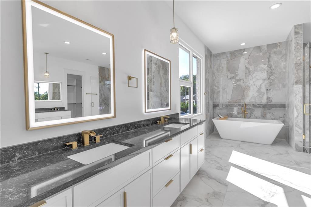 1939 Sunny Hill Road Lawrenceville, GA 30043 - Photo 33 of 47 a spacious bathroom with a double vanity sink large mirror and a bathtub