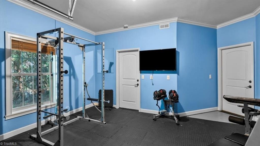 5917 Crutchfield Farm Road Oak Ridge, NC 27310 - Photo 35 of 46 Semi-Finished workout space with roll-up door overlooking backyard.