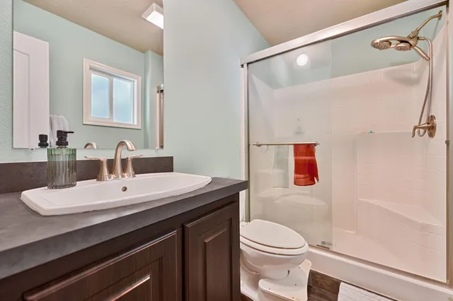 a bathroom with a sink a toilet and shower