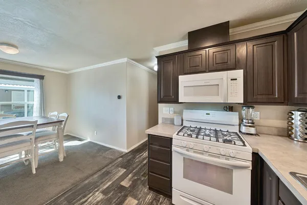a kitchen with a stove cabinets and wooden floor